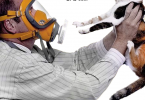 Foto di un uomo che indossa una maschera a GAS e tiene in mano il suo gatto
